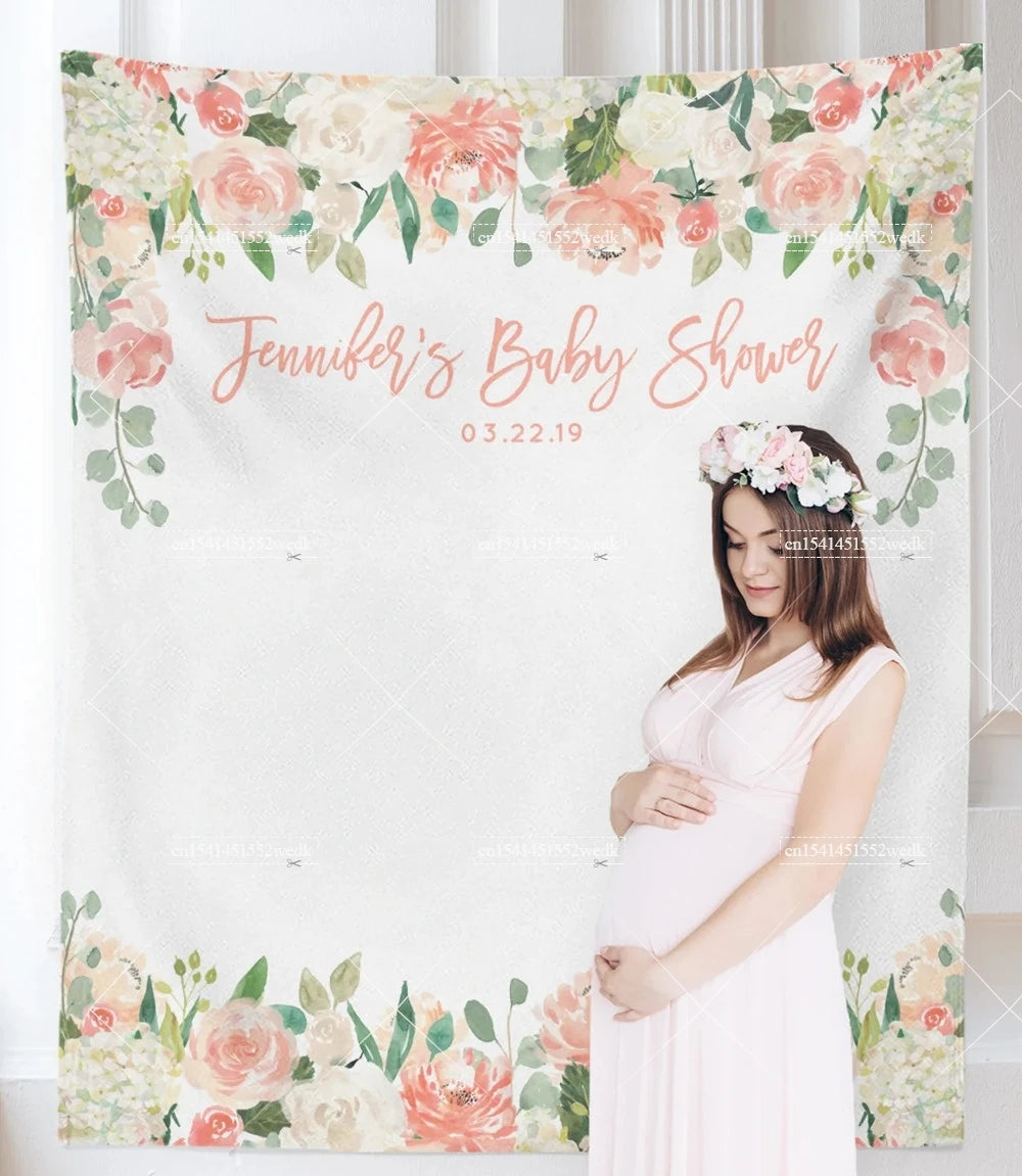 A pregnant woman in a pink dress stands in front of a floral tapestry announcing Jennifer's baby shower.
