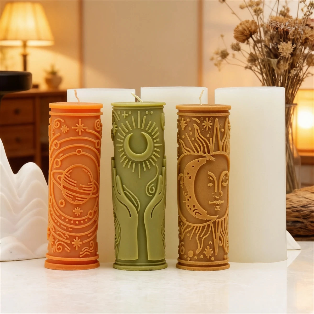 Three decorative silicone candle molds in orange, green, and tan featuring celestial designs for DIY wax crafts