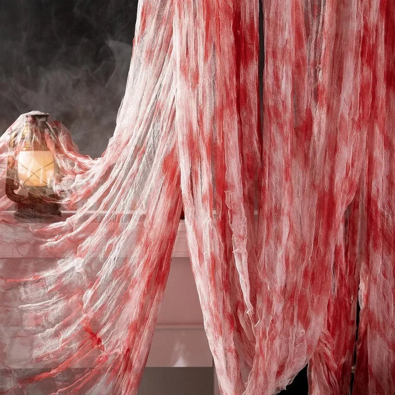Red and white gauzy cloth draped in a flowing fabric with wispy texture, used for Halloween decor.