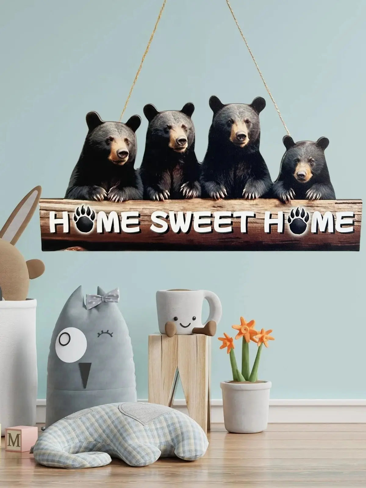 A rustic wooden inspirational hanging sign featuring four bear figures with paw prints, displayed on a light blue wall.