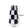 A tall ceramic tabletop vase with a black and white checkerboard pattern.