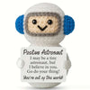 A white crochet doll resembling an astronaut wearing a helmet with a card that says I may be a tiny astronaut but I believe i