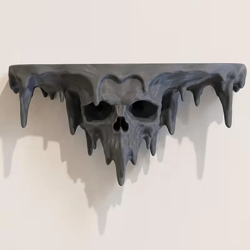 A dark, melted skull wall shelf with dripping features, displayed against a light background.