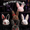 A collection of dark and light colored bunny plush keychains and toys displayed in a box.
