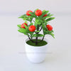 Artificial lemon tree bonsai with bright red fruit on a green leafy branch planted in a white pot