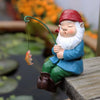 Keramische Gnome-Statue mit rotem Hut und blauer Kleidung, die mit einer grünen Leine und einem kleinen orangefarbenen Fisch 
