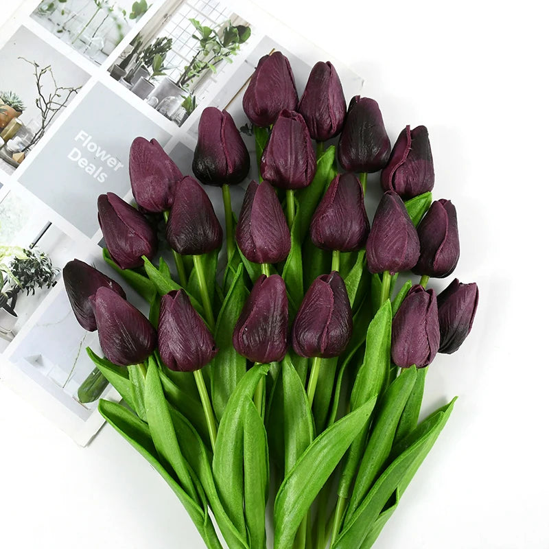 A bouquet of deep purple artificial tulips with green stems and leaves.