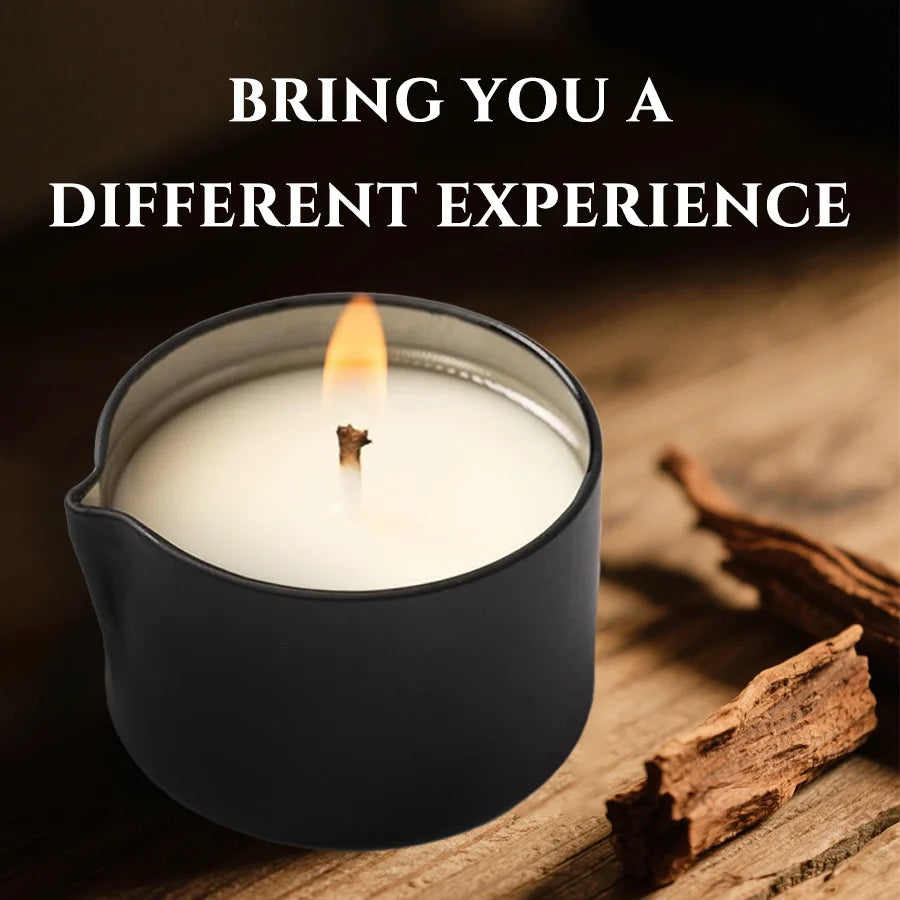 A black jar candle is lit, casting a warm glow on a wooden surface next to cinnamon sticks.