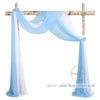 A wooden arch decorated with flowing white and light blue chiffon fabric drapes.