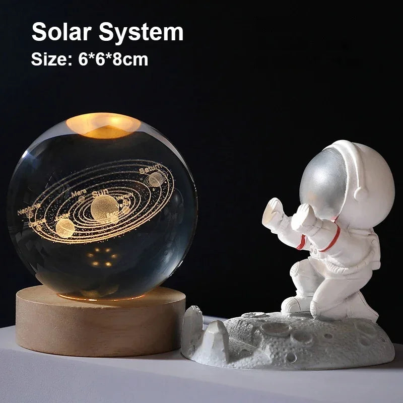 A glass crystal ball model of the solar system rests on a wooden base next to a white astronaut figurine.