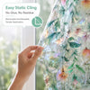 A hand is applying vintage floral mosaic window film to a window, demonstrating its easy static cling application.
