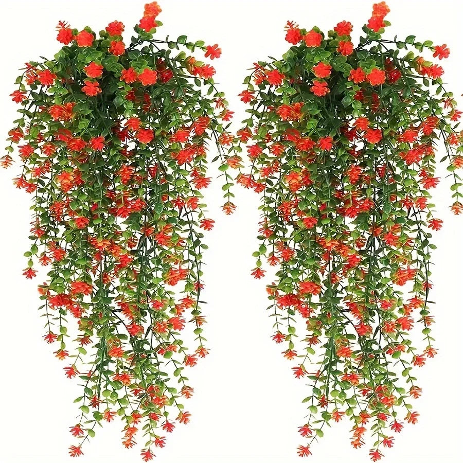 Set of three lifelike faux eucalyptus hanging plants with vibrant red and orange flowers