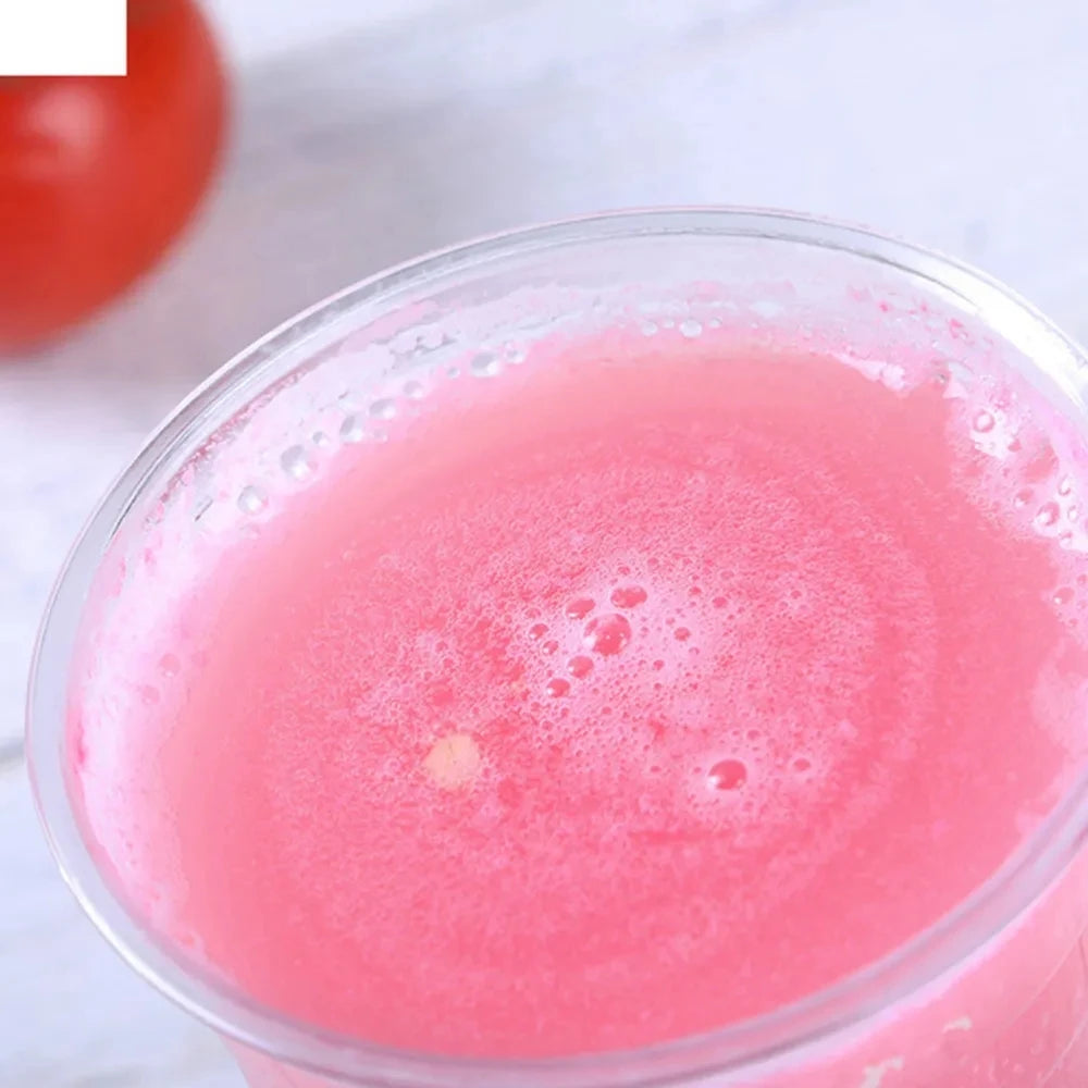 A close-up of a pink, bubbly liquid in a clear plastic cup with a dome lid.