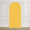 Arco de fondo amarillo elástico vertical exhibido contra una pared blanca con molduras decorativas.