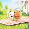 A set of cute bear-themed fridge magnets featuring white and orange designs displayed on a green plate in an outdoor setting.