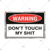 A vintage metal warning sign with a red oval banner that reads WARNING and below it says DON'T TOUCH MY SHIT.