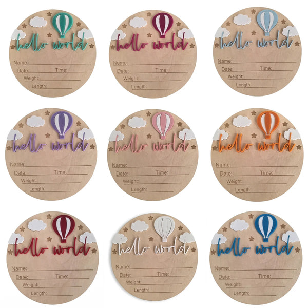 Un juego de seis placas de madera redondas con ilustraciones acuareladas de globos aerostáticos y texto para anuncios de naci