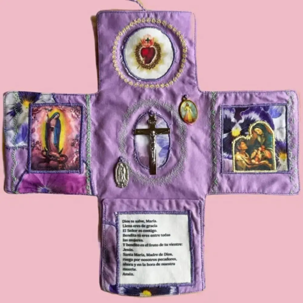 Handcrafted pocket devotional with a cross-shaped pouch featuring religious imagery on a purple fabric.