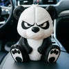 A white and black angry panda figurine sitting on a car dashboard.