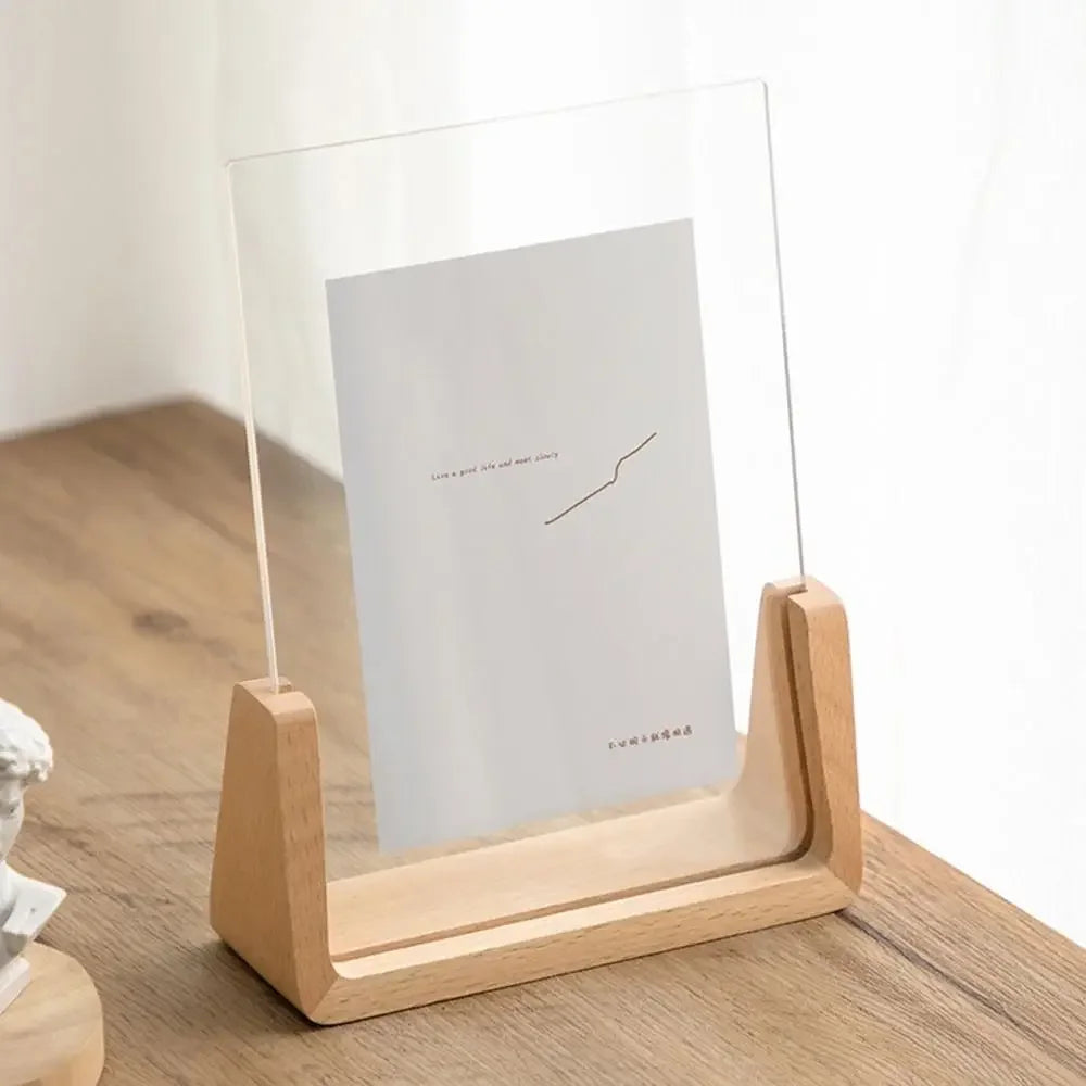 A walnut wood and acrylic photo frame displaying a minimalist line drawing on a light background.