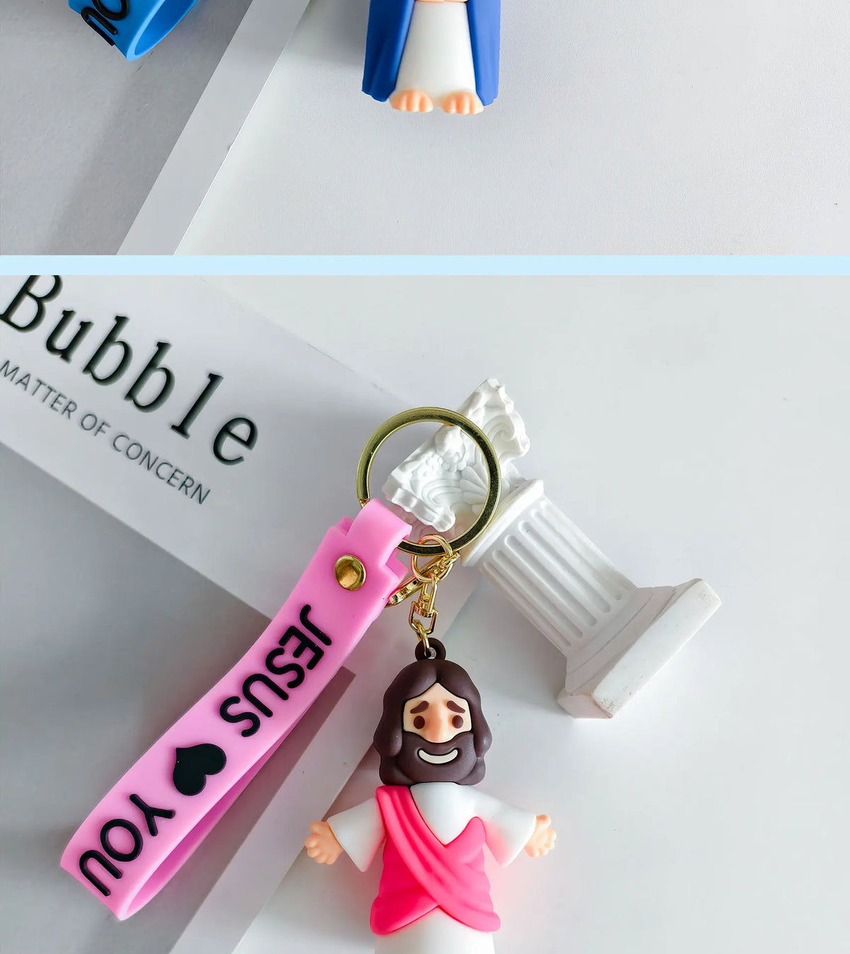 A silicone keychain featuring a Jesus figure and a pink strap with a heart design.
