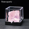 A rough pink rose quartz crystal specimen displayed inside a clear square box.