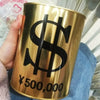 A close-up of a gold-colored metal piggy bank with a large black dollar sign and the text ¥500,000 printed on it.