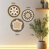 Three round boho straw wall hangings with woven tassels displayed on a light-colored wall.