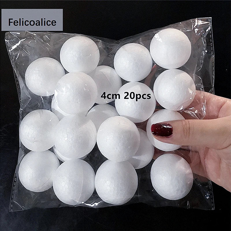 A hand holds a clear plastic bag filled with 20 white polystyrene foam balls for crafting.