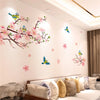 Wall stickers featuring colorful birds and pink cherry blossoms on a white wall.