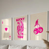 Three framed art prints featuring pink and purple retro letter designs on white backgrounds