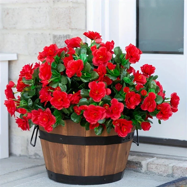 A vibrant potted artificial red azalea bush with green leaves displayed on a doorstep.