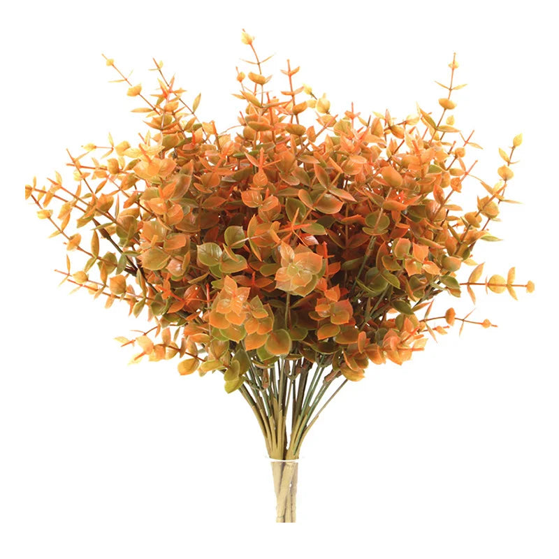 A bouquet of artificial fall eucalyptus and flower stems in shades of orange and green.