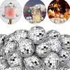 A collection of silver disco ball ornaments and a pink cake with gold accents.