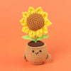 Handmade crochet sunflower desk companion with a smiling face, featuring yellow petals and a brown center.