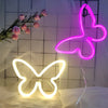 Two glowing neon butterfly signs, one pink and one white, displayed against a white background.