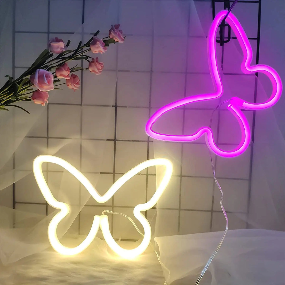 Two glowing neon butterfly signs, one pink and one white, displayed against a white background.
