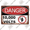 A vintage metal warning sign with red and white text indicating danger and 10,000 volts.