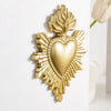 Gold resin wall decoration shaped like a heart surrounded by radiating flame-like leaves