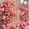 A large arrangement of pink heart-shaped foil balloons clustered together for a party decoration.
