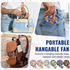 A portable foldable cooling handheld fan is shown being used to cool a bag and a hand fan is displayed.