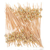 A bundle of pearl-tipped bamboo cocktail picks with a gold finish.