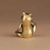 A vintage brass frog statue ornament sitting on a neutral background.