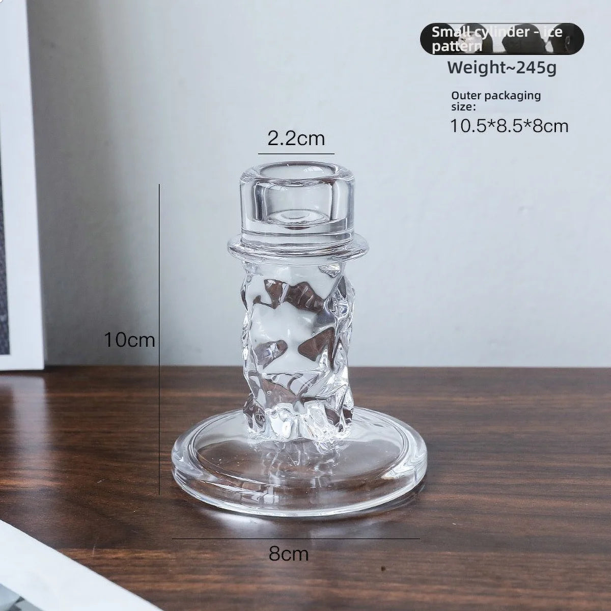 Elegant clear glass pillar candle holder with a decorative etched design on a round base