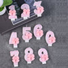 A collection of glitter number candles from 1 to 9, featuring pink bows, displayed on a dark gray surface.