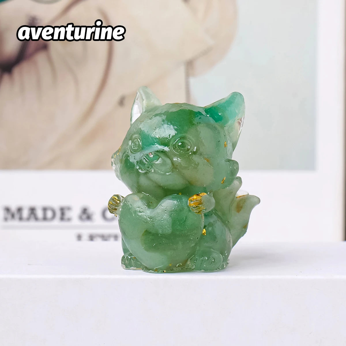 A small, translucent green aventurine crystal sculpture shaped like a fox, used for Feng Shui decor.
