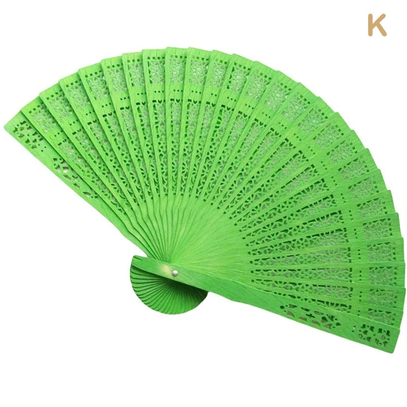 A bright green hand carved bamboo folding fan shown open and angled.