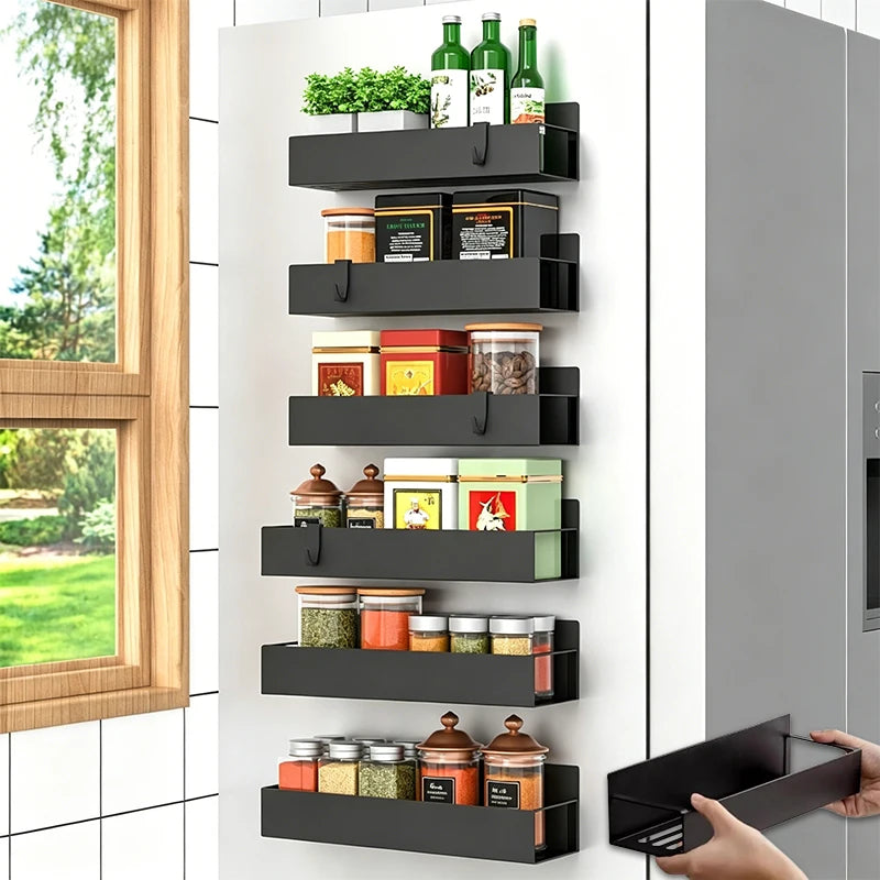 A black magnetic spice rack with multiple tiers is mounted on a white cabinet door.