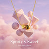 Gold heart basketball pendant necklace set against a soft pink and purple cloudy background