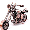 A handcrafted metal motorcycle model with a vintage finish and detailed engine components.